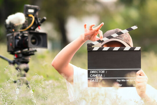Story telling. teenage boy holding a film slate or film clapper board in the movie industry. new content creator, young filmmaker.