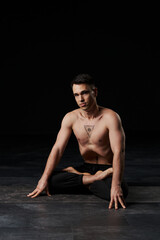 The man in lotus position, stomach vacuumed, displays a powerful all-seeing eye tattoo on his...
