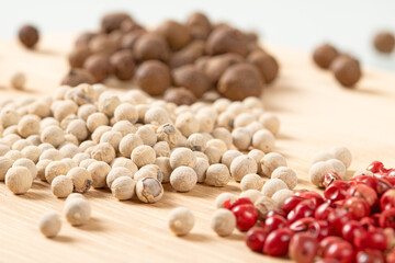 Detailed macro image showcasing a blend of black, white, and red peppercorns in close-up