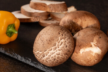 Fresh whole and sliced mushrooms on dark background for culinary ingredient and nutrition concept