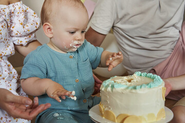 The little boy's face is covered in frosting as he embraces the messy fun of his birthday bash.