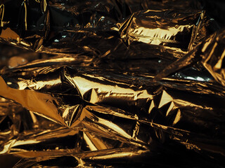 Golden light reflected on foil at night for an abstract luxury background. 