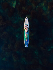 Woman relax on stand up paddle board at sea. Enjoying on sup board. Aerial view