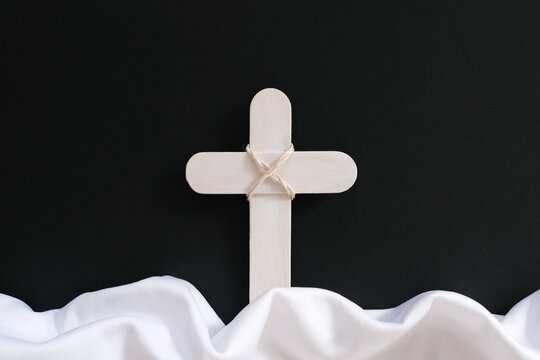 White wooden cross and fabric as symbol of heaven. Funeral and burial backdrop and sympathy card design.