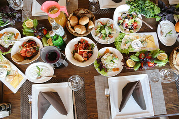 Table Overflowing With Platters of Food and Glasses of Wine