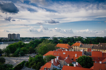 Obraz premium Petrovaradin, Serbia - May 09, 2023. Petrovaradin is historic town on right bank of Danube in Serbia, part of Novi Sad. Top view of the tiled orange roofs with white chimneys and magic cloudy sky