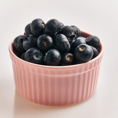  Delicious group of blueberries on ceramic bowl over isolated white background