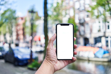 Man holding smartphone showing white blank screen at amsterdam