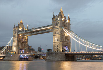 Obraz premium Beautiful scenery view of famous Tower bridge and skyline with reflections in the river thames just after sunset. The illuminated Tower Bridge, Space for text, Selective fo