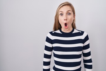 Young caucasian woman wearing casual navy sweater afraid and shocked with surprise expression, fear and excited face.