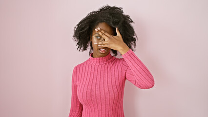African adult woman in pink gesturing indoors with a curious expression, evoking a sense of inquiry...