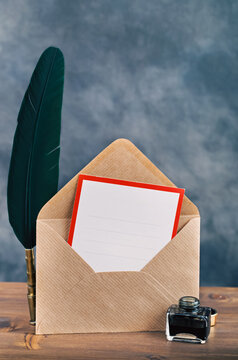 Envelope with empty card and quill pen