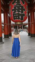 Beautiful hispanic woman in glasses captured walking away, revealing back view at majestic senso-ji...