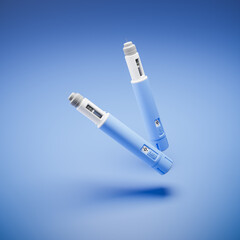 Two injectors / dosing pens  for subcutaneous injection of antidiabetic medication or anti-obesity medication hovering over a blue background. - obrazy, fototapety, plakaty