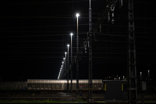 Freight station at night in Zurich, Spreitenbach. Freight trains are illuminated by bright headlights. In the background is a light layer of fog.