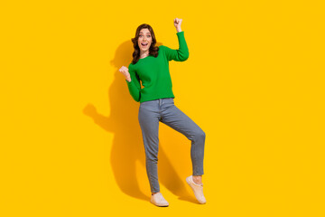 Full body size photo of charming overjoyed young positive girl champion yeah screaming raise fists up isolated on yellow color background