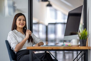 Asian business woman using computer with empty blank screen, sitting at workplace in the office, offering space for mockup on monitor. Male CEO showing place for online ad