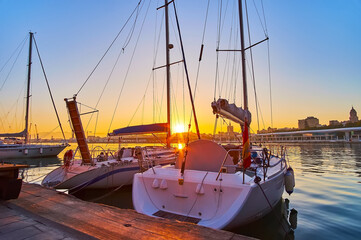 The sunset behind the yachts sails, Malaga Port, Spain