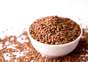 Organic Whole Brown Flax Seeds in a White Ceramic Bowl. View from Above.