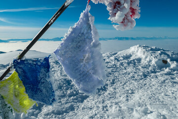 Frozen Nepalese Himalaya flags with panoramic view of Karwanks and Julian Alps seen from Grosser...