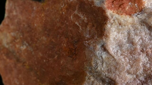 Sunstone (oligoclase feldspar with hematite inclusions) from India rotating slowly against a black background