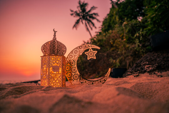 Lantern with crescent moon shape on the beach with sunset sky, 2024 Eid Mubarak greeting background, Ramadan Kareem photography, Ramadan greeting background