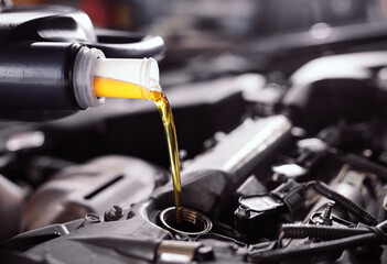 Motor oil pouring to car engine. - obrazy, fototapety, plakaty