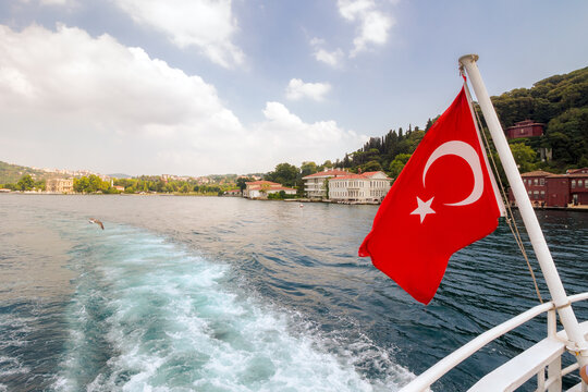 istanbul, turkey - 18 aug 2015: turkish flag on the back of the boat. wonderful view of the eastern shore of bosporus