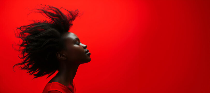 Stylish black woman smiling on red background in studio. Confident black woman with curly hair on red background. Background woman black hair person beauty face female woman portrait african young.