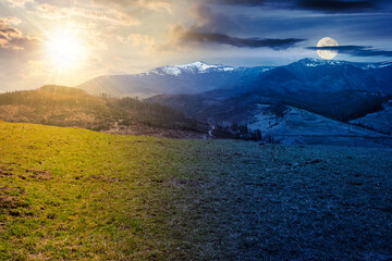 carpathian rural landscape in springtime. grassy meadow on the alpine hill. snow capped mountain in...