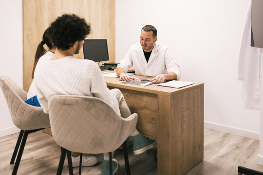 Doctor reviewing x-ray results with patients in office