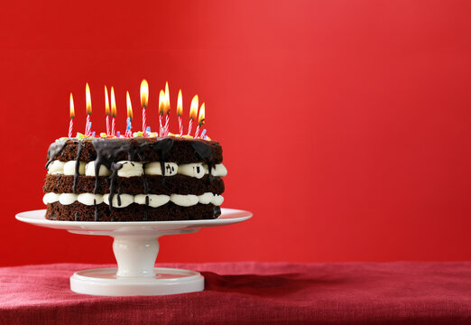 chocolate birthday cake with berries on a red background