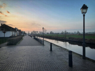 Evening light at empty street. Hylkemaweg at Giethoorn watervillage Overijssel Netherlands. Sunset and canal. 