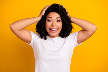 Photo of crazy overjoyed ecstatic woman dressed white t-shirt hold arms on head astonished staring...