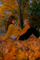 mother and child boy playing in autumn park, happy family, mother and baby outdoors in park