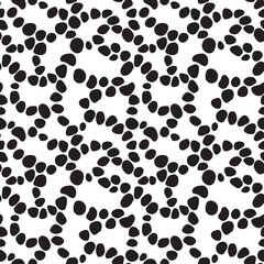 Organic black dots organized in curved lines seamless pattern. Pebble shaped elements repeated on white background. Creative texture for printing on various surfaces or usage in graphic design.