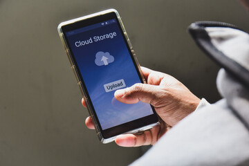 Person using online file sharing storage service to upload and backup personal data on his mobile device.
