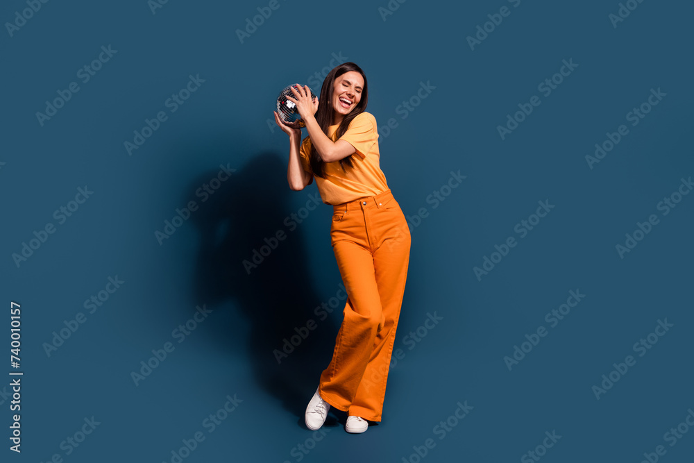 Sticker Full body size photo of hipster girl night club wear orange garment raised hands with old disco ball isolated on dark blue color background