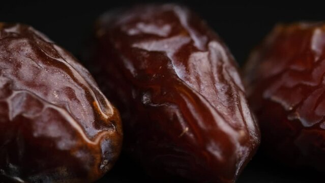 Dried dates, dried fruits on a black background close-up.