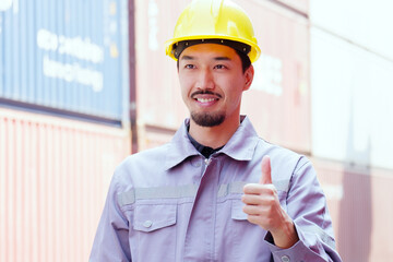 Male engineer wearing safety helmet standing and smiling.