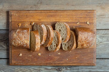 Fresh baked buckwheat (whole grain) bread, on a wooden background. Crispy baguette with a delicate...