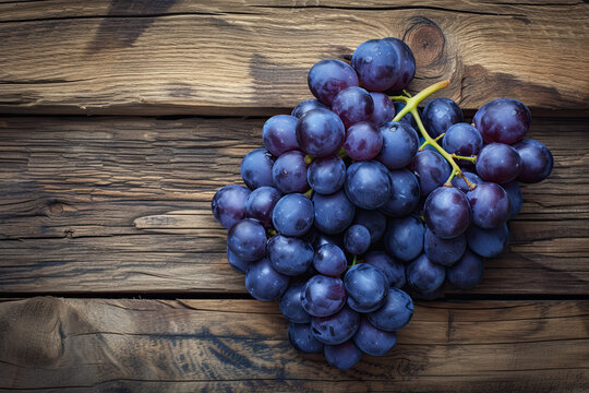 top view a bunch of purple grapes on a wooden background