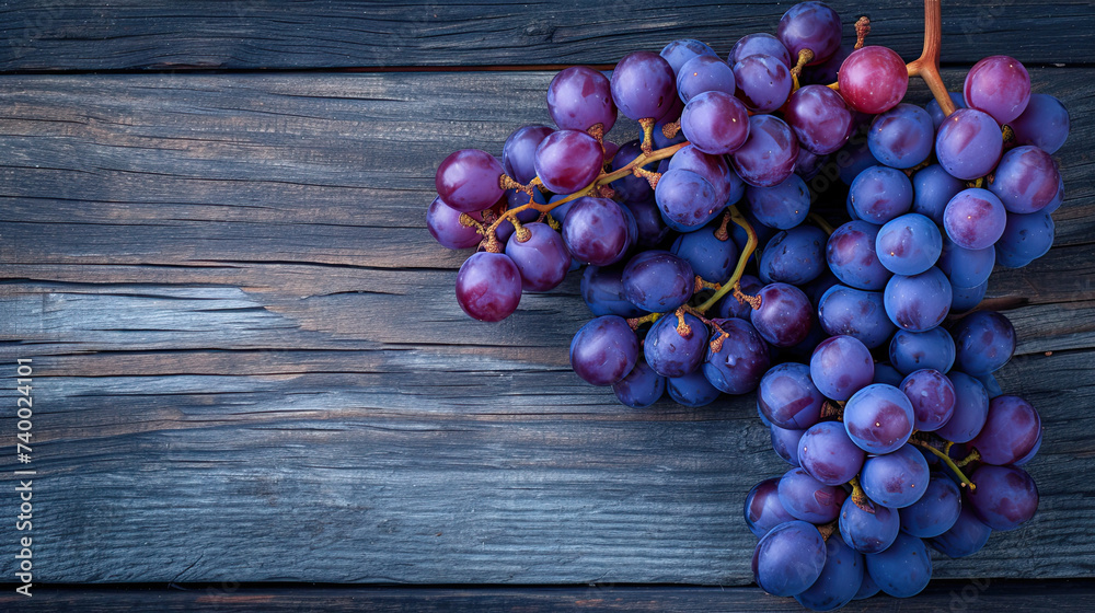 Wall mural top view a bunch of purple grapes on a wooden background