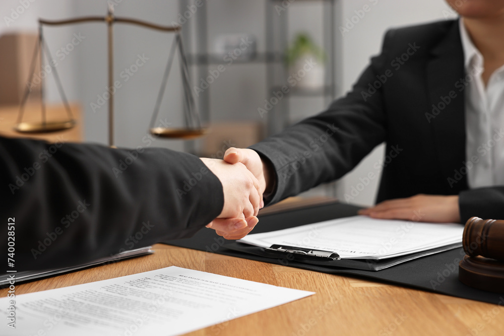 Poster Notary shaking hands with client at wooden table in office, closeup