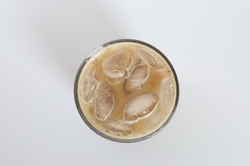 Iced coffee in glass on white background, top view