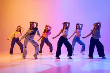 Group of active people, talented dancing hip hop against gradient studio background in neon light. Contemp. Concept of hobby, youth, childhood, style, fashion, dance school - obrazy, fototapety, plakaty