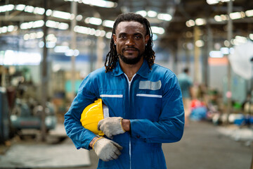 Portrait of a black male mechanical engineer working at a metal lathe factory. Worker working with...
