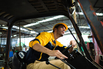 Male worker drives a forklift in an industrial container warehouse. Male factory worker driving a...
