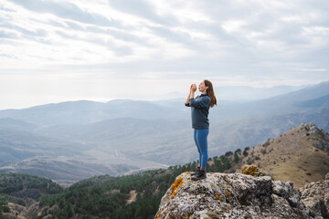 woman screaming celebrating vacation at sunset in the mountain successful woman hiker shouting...