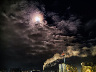 Winter night industrial landscape. Coal-fired power station with smoking chimneys against dramatic...